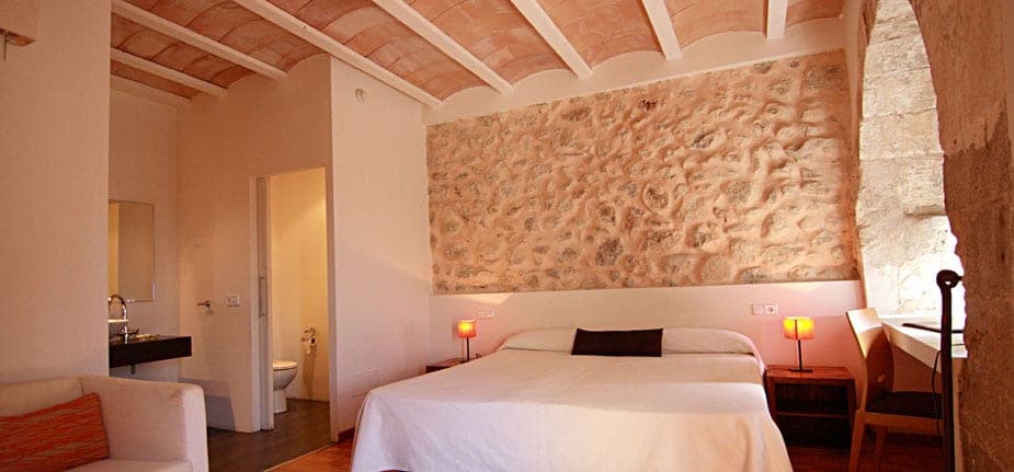 Zimmer mit Natursteinwand im Petit Hotel Can Riera