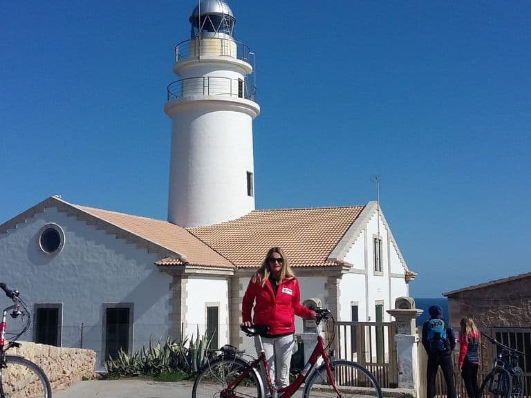 Radfahrer-Gruppe am Leuchtturm an der Ostküste Mallorcas
